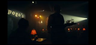 Klub komediowy, w którym swoich sił próbuje Arthur Fleck, nazywa się „Pogo’s”; Pogo to pseudonim, który nosił seryjny zabójca John Wayne Gacy – w latach 1972-1978 zamordował on 33 nastolatków, dusząc i gwałcąc swoje ofiary. 