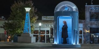 W Tulsie (możemy założyć, że także w innych amerykańskich miastach) stoją specjalne budki, dzięki którym można wysłać wiadomość znajdującemu się na Marsie Doktorowi Manhattanowi. Wygląda jednak na to, że mieszkańcy USA zdają sobie sprawę, że Manhattan ich nie słucha – Laurie wciąż z nich korzysta na zasadzie autoterapii. Sam heros przedstawiając się jako istota boska jednocześnie dawał do zrozumienia, że nie zależy mu dłużej na ludzkości. Ludzie „modlący się” więc do niego poprzez budki pokazują, jak bardzo cywilizacja nie zrozumiała założeń idei Manhattana. 